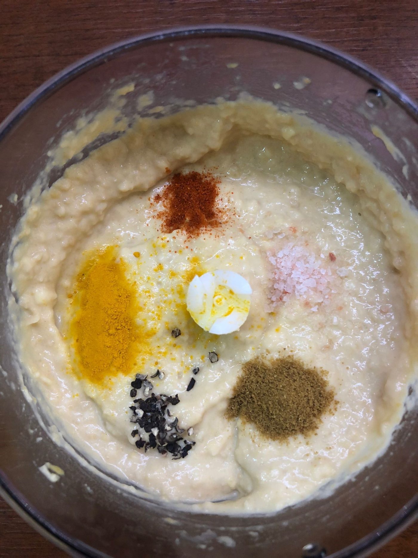 Hummus met olijfolie en tomaatstukjes in blauw-wit kommetje