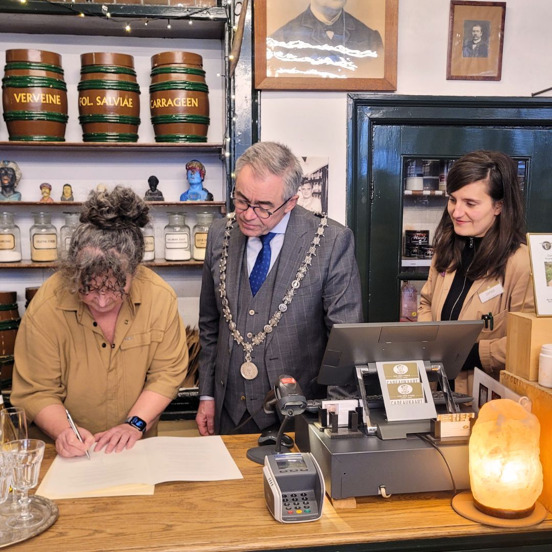 astrid, sophie, burgermeester wienen van Haarlem in de winkel met ondertekening hofleverancier bestendiging