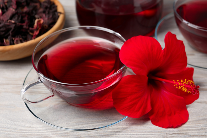 Hibiscus bloem met kop thee met witte houten tafel