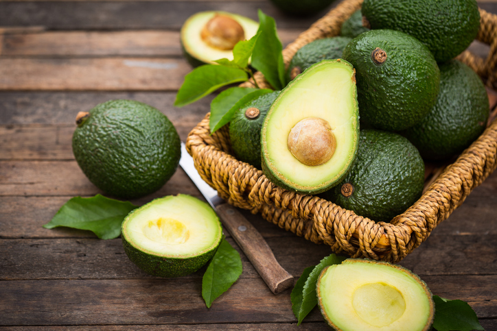 avocado's in een mand op een houten tafel