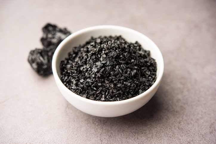 shilajit in witte pot, grijze achtergrond